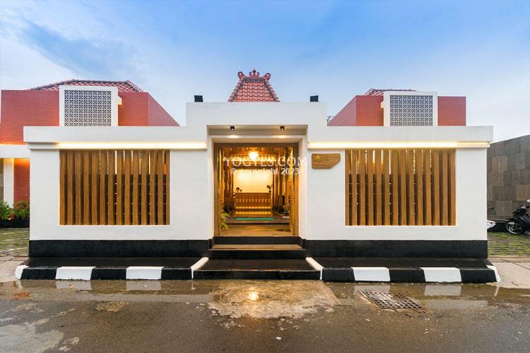 a white and red house with a staircase in front of it at KESATRIYAN JOGJA GUEST HOUSE in Yogyakarta