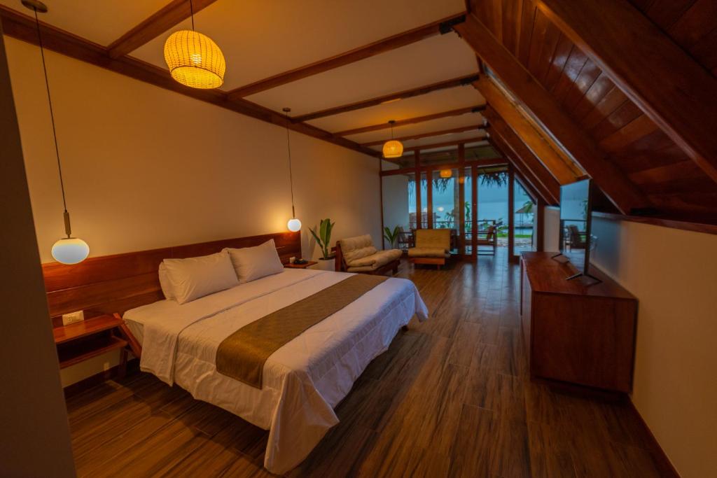 um quarto com uma cama grande e uma sala de estar em Riosol Hotel Laguna Azul em Sauce