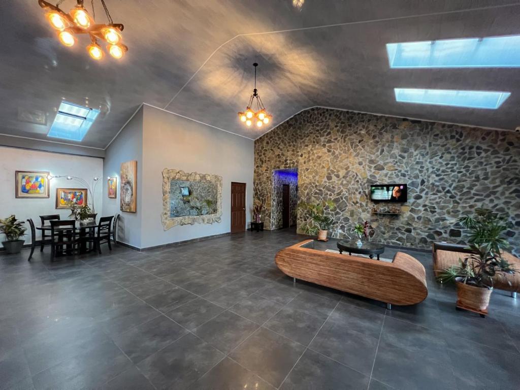 a living room with a couch and a stone wall at Cabañas Lago Cerro Azul - Lake of Panama in Cerro Azul