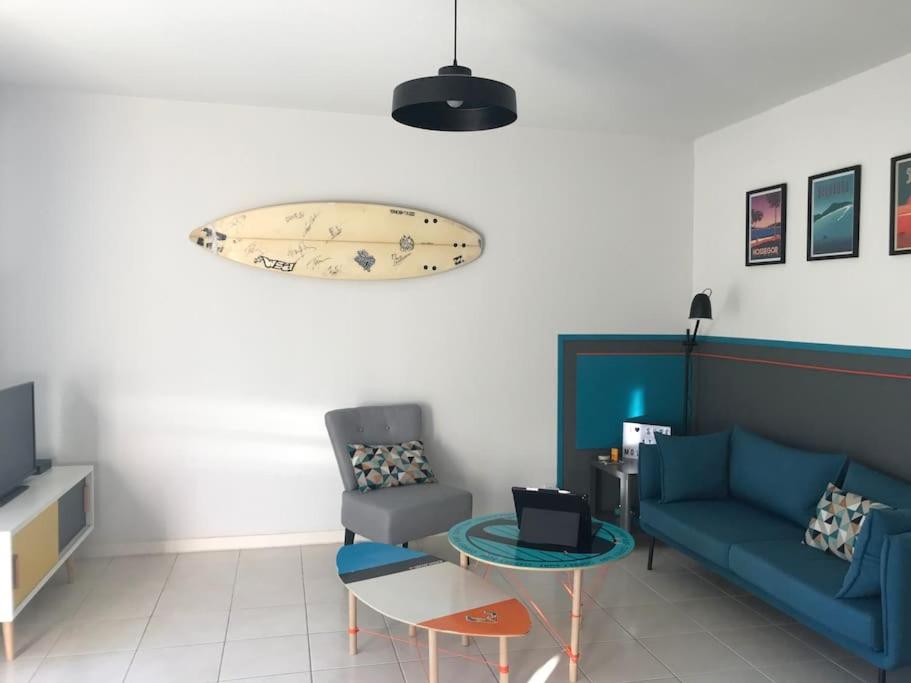 sala de estar con sofá azul y mesa en Maison à 300m de la plage, en Moliets-et-Maa