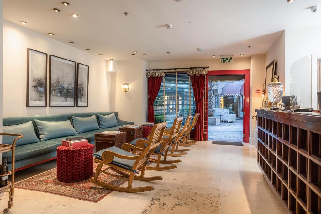 uma sala de estar com um sofá verde e cadeiras em Arthur Hotel - an Atlas Boutique Hotel em Jerusalém