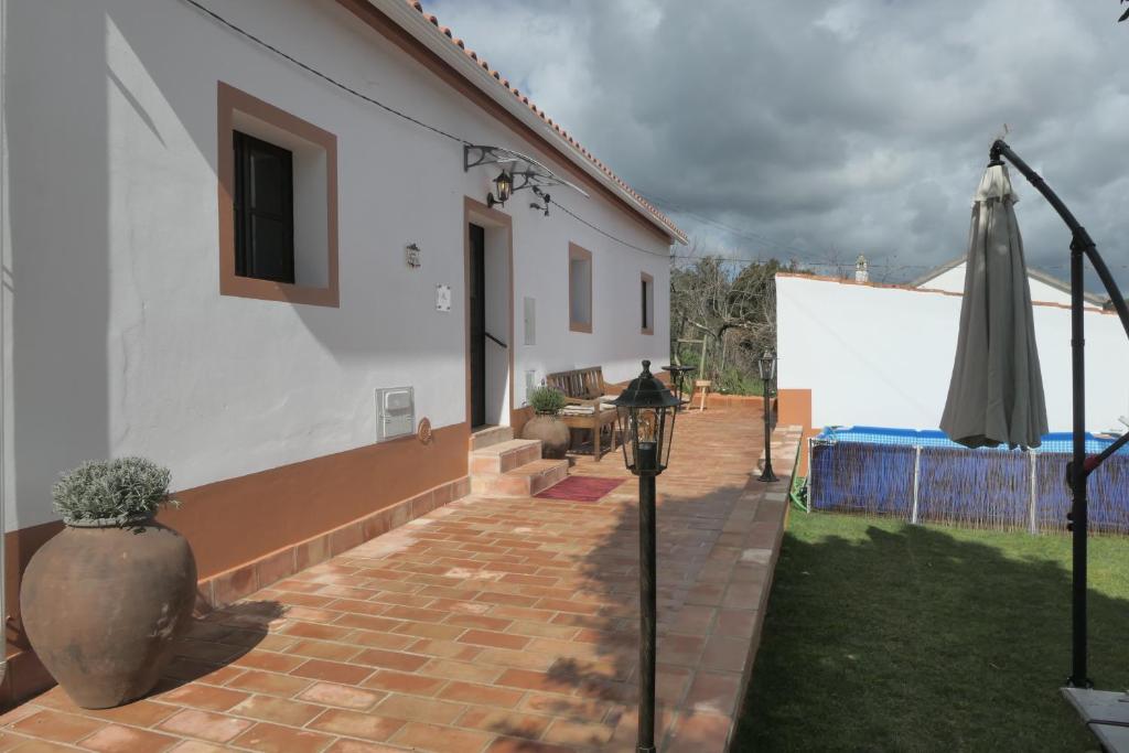 a patio with an umbrella next to a house at Casa Alegria in Sabóia