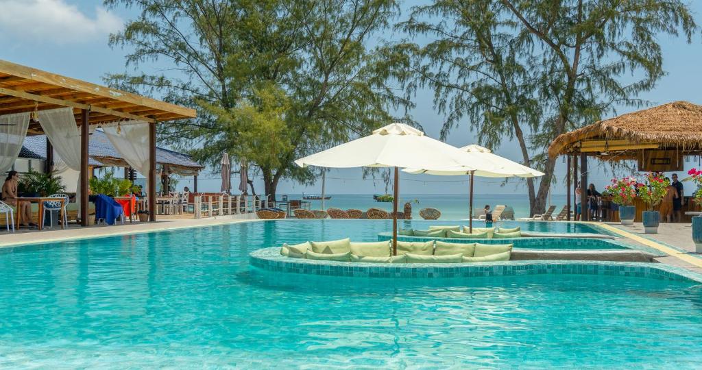 - une piscine avec des chaises et un parasol dans l'établissement Sara Resort, à Koh Rong Sanloem