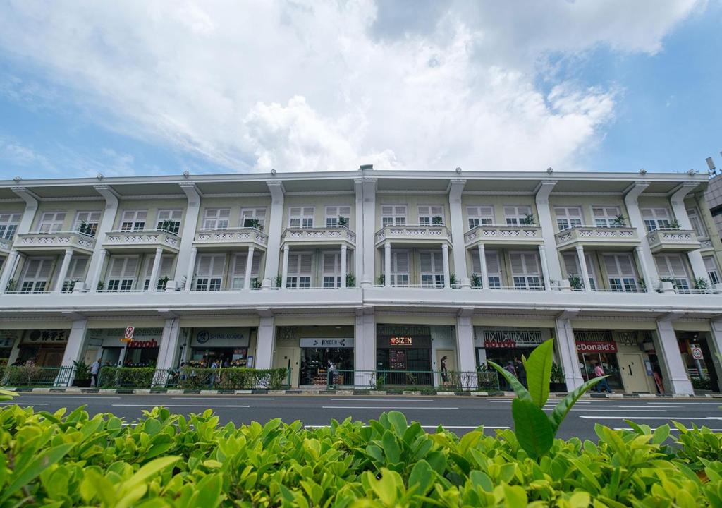 a large white building on the side of a street at hovoh homes Bugis Rochor in Singapore