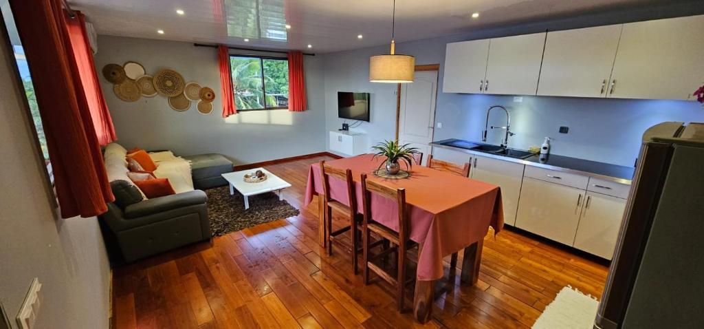 a kitchen and a dining room with a table in a room at Spacieux et charmant Appartement Heremata - Arue - Tahiti in Arue