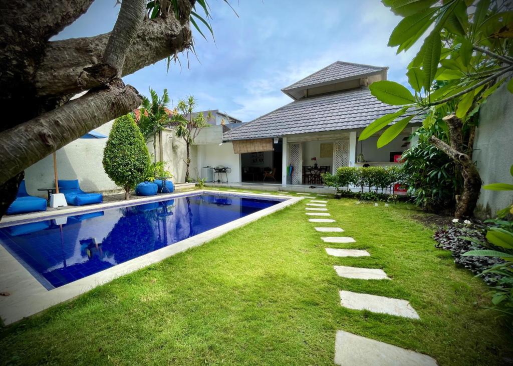 a backyard with a swimming pool and a house at Villa Majegau 1 by Deasha in Seminyak