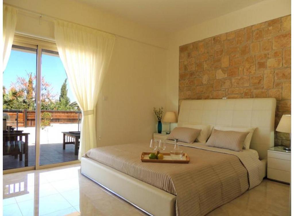 Un dormitorio con una cama con una mesa encima. en Dream House Latchi Villa, en Polis Chrysochous