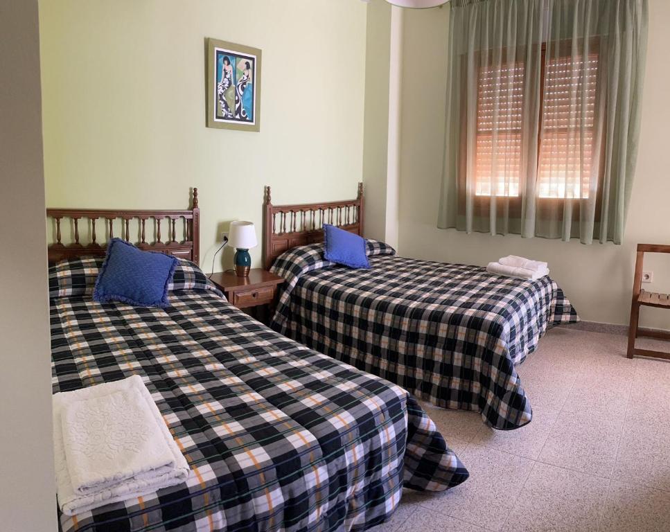 een slaapkamer met 2 bedden en blauwe kussens bij CASA BRIGIDA in Jerte