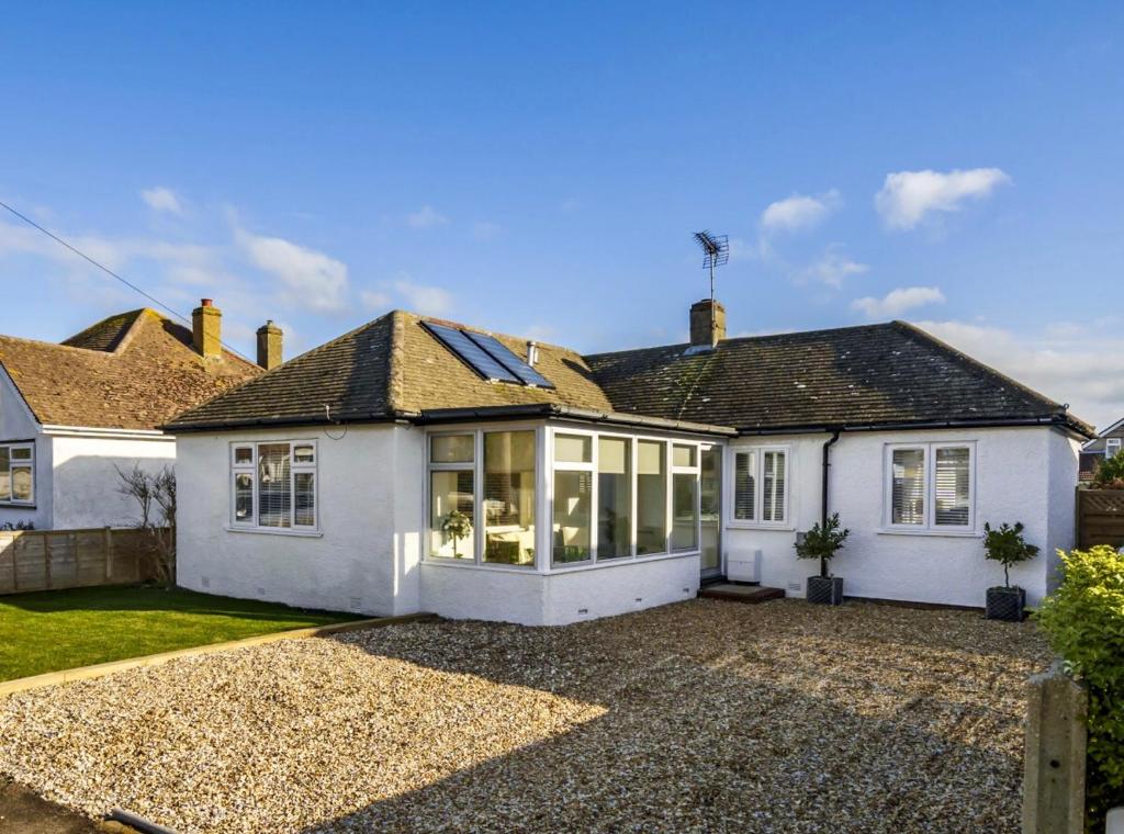 a white house with a lot of windows at Beautiful Bungalow near to Beach in Selsey