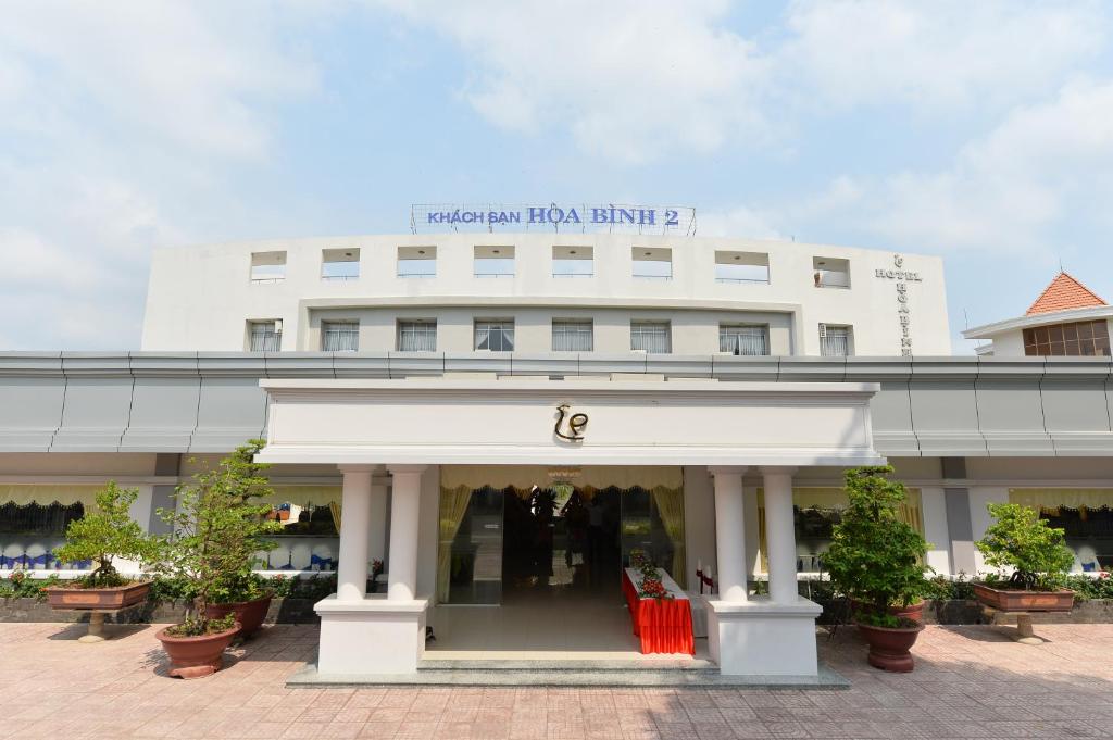 un edificio blanco con una tienda delante de él en Nhà Hàng Khách Sạn Hòa Bình 2, en Long Xuyen