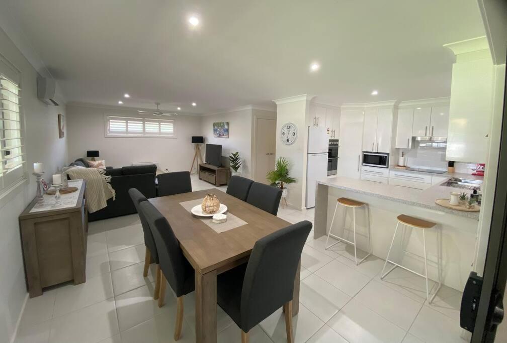 a kitchen and a living room with a table and chairs at Worrigee Retreat Guesthouse in Worragee