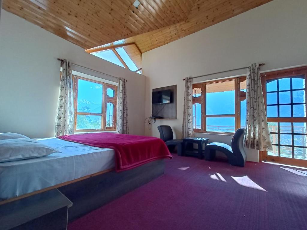 a bedroom with a bed and a large window at Shepherd Inn the Hill in Nagar