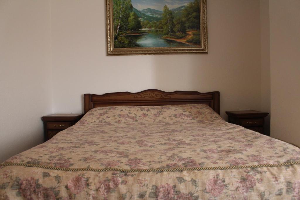 Ce lit se trouve dans une chambre ornée d'une peinture murale. dans l'établissement Gostyniy Dvir Synevir, à Lac Synevyr
