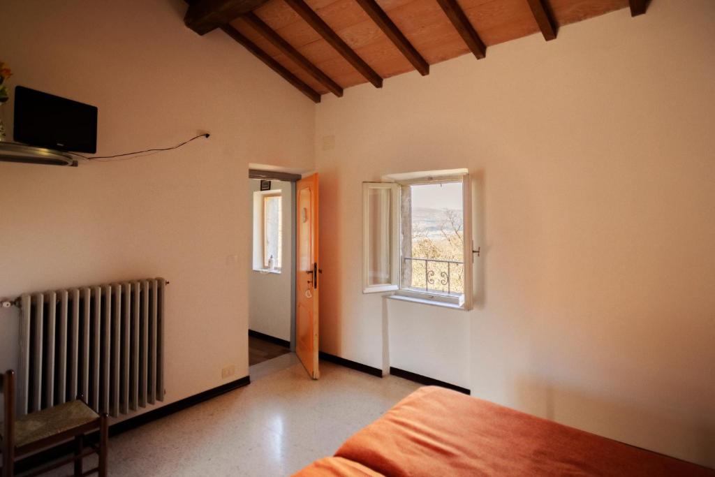 Habitación vacía con cama y ventana en La Casa di Augusto, en Bomarzo