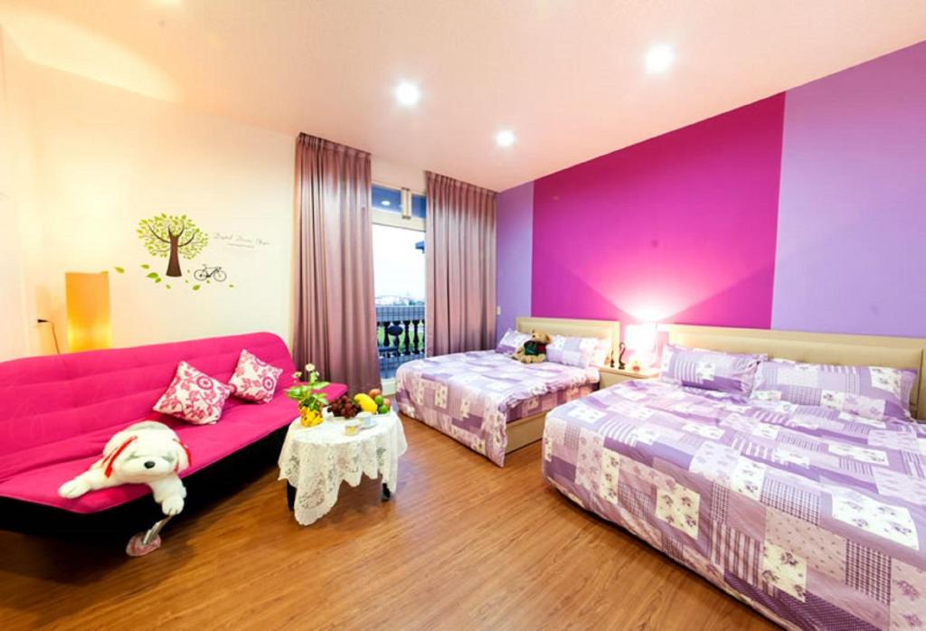 a bedroom with two beds and a pink wall at Free World B&B in Wujie