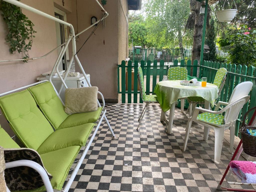 un patio con un sofá verde y una mesa en Grany's Retro Guesthouse near Budapest AirPort, en Vecsés