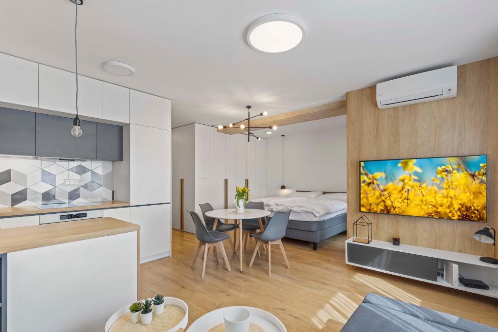 a kitchen and a living room with a dining room at LAM Concrete w AC & Balcony in Bratislava