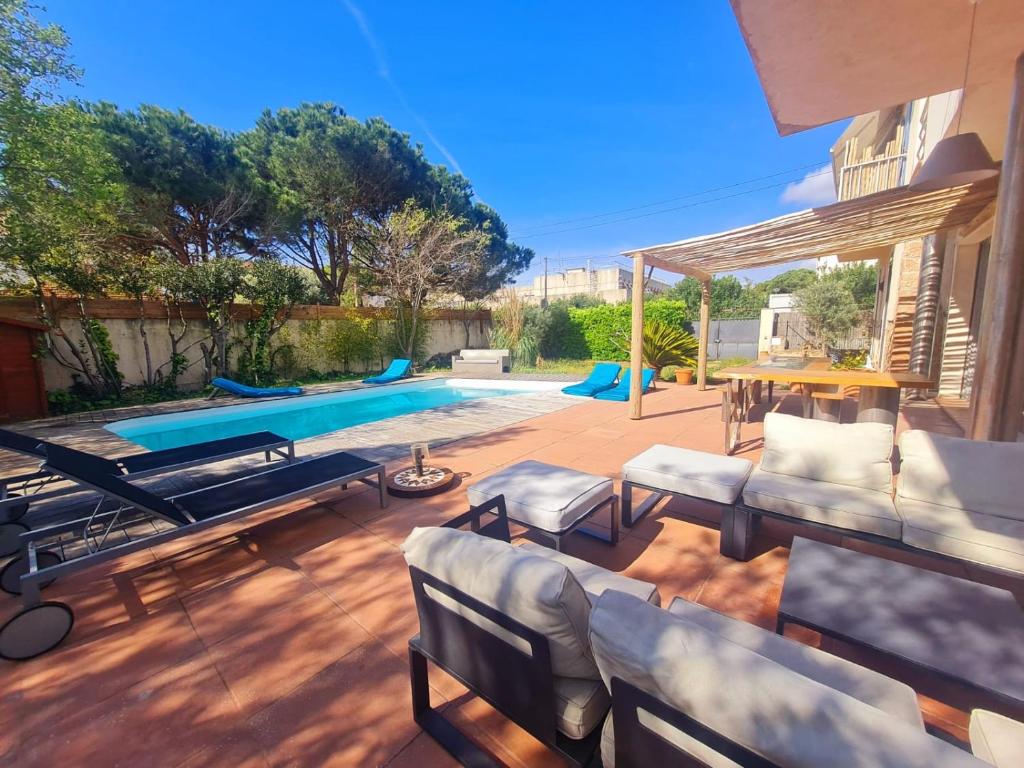 聖拉斐爾的住宿－Coeur de ville maison piscine，庭院设有游泳池、椅子和桌子。