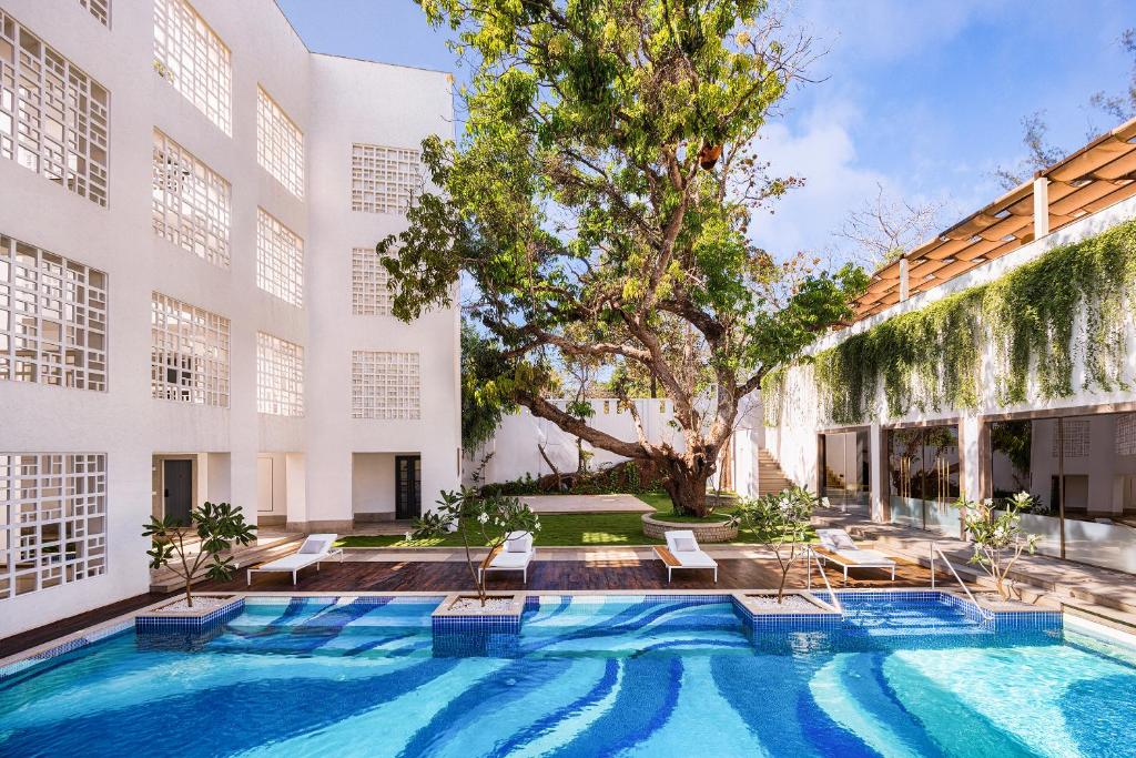 a swimming pool in the courtyard of a building at The Yellow House, Goa - IHCL SeleQtions in Anjuna