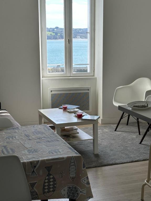 uma sala de estar com uma mesa e uma janela em Appartement Design III - Port du Rosmeur - Douarnenez em Douarnenez