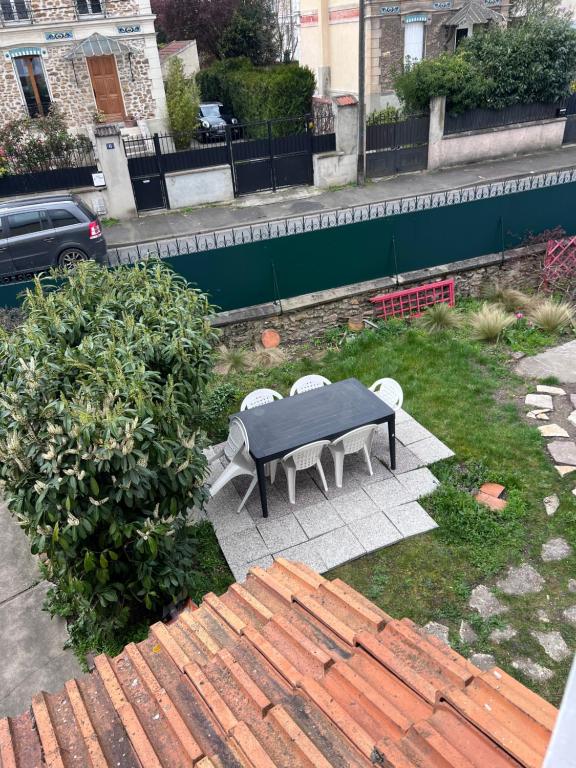 a table and chairs sitting in the grass at Maison Climatisée 04 chambres Paris Disney CDG in Gagny