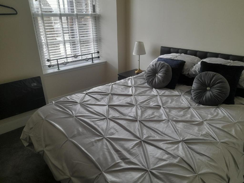 ein Schlafzimmer mit einem großen Bett mit Kissen darauf in der Unterkunft Kirkcudbright Holiday Apartments - Apartment E in Kirkcudbright