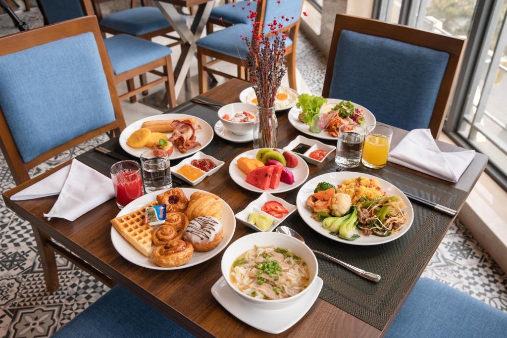 A generously set breakfast table beside tall windows.