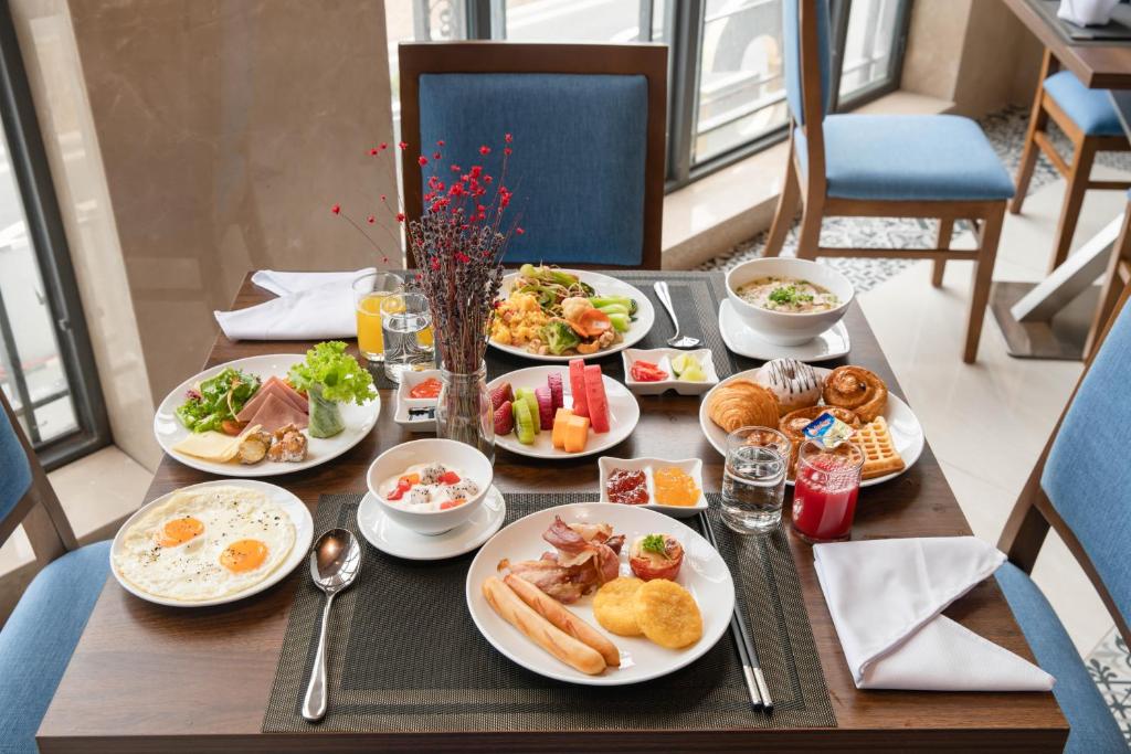 A generously laid breakfast table beside tall windows.