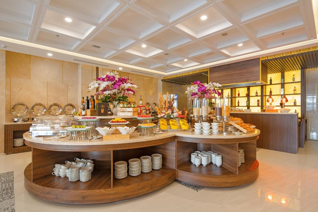 Two curved buffet islands present fruit, drinks, pastries and hot dishes beneath floral arrangements.