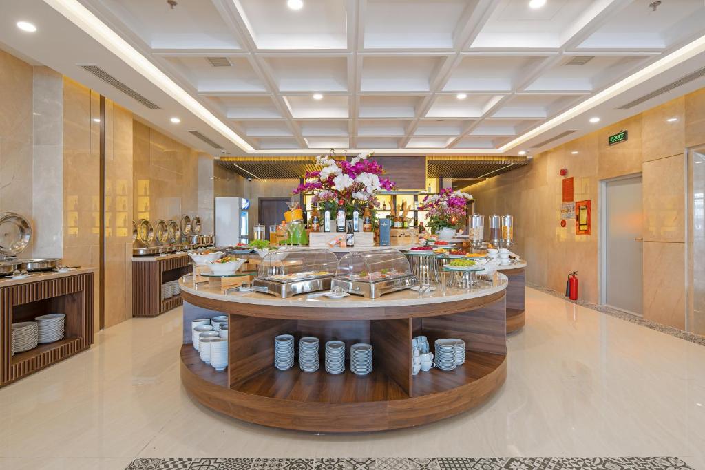 A central round buffet island anchors a bright hotel breakfast room.