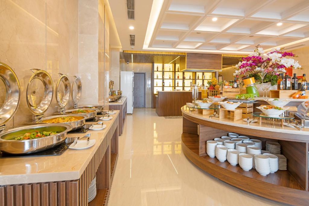 A buffet line and curved central island display hot dishes, bowls and breakfast items.