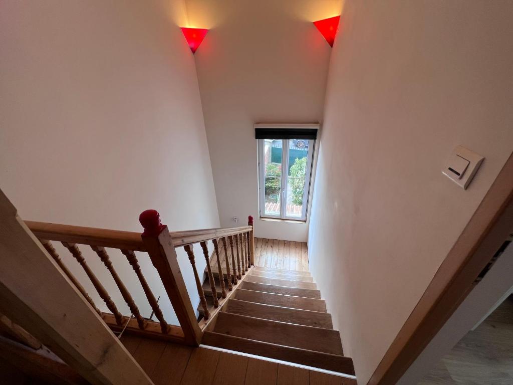 a staircase with red lights on the wall and a window at Maison Climatisée 04 chambres Paris Disney CDG in Gagny