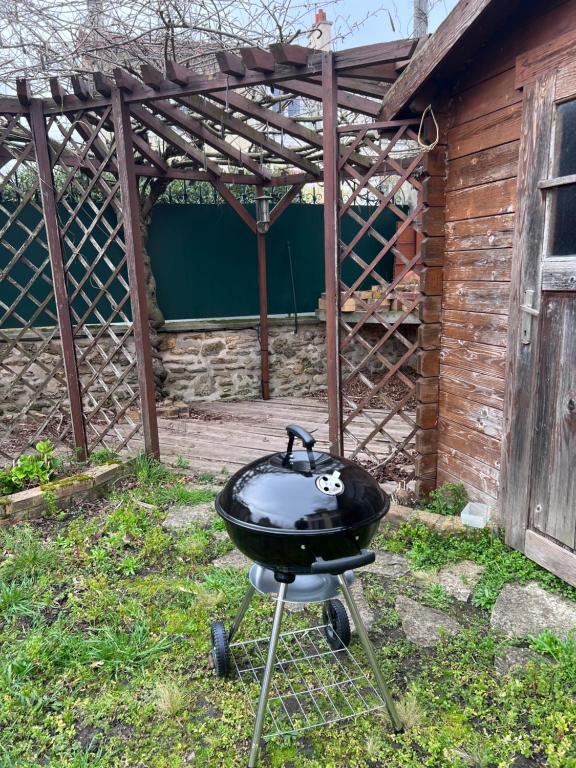 a bbq grill in front of a building at Maison Climatisée 04 chambres Paris Disney CDG in Gagny