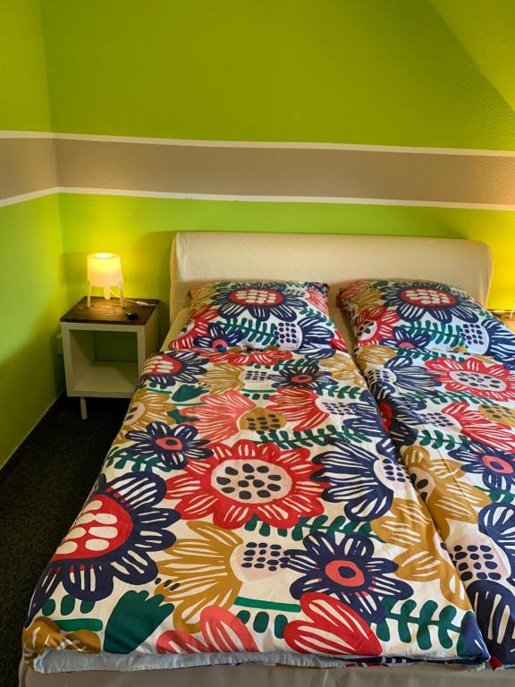 Bett mit farbenfroher Bettdecke in einem Zimmer in der Unterkunft Hotel Zur Schleuse (Garni) in Datteln