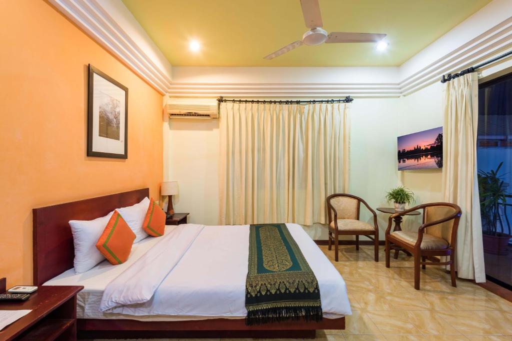 シェムリアップにあるSihariddh BnB Villaのベッド、テーブル、椅子が備わるホテルルームです。