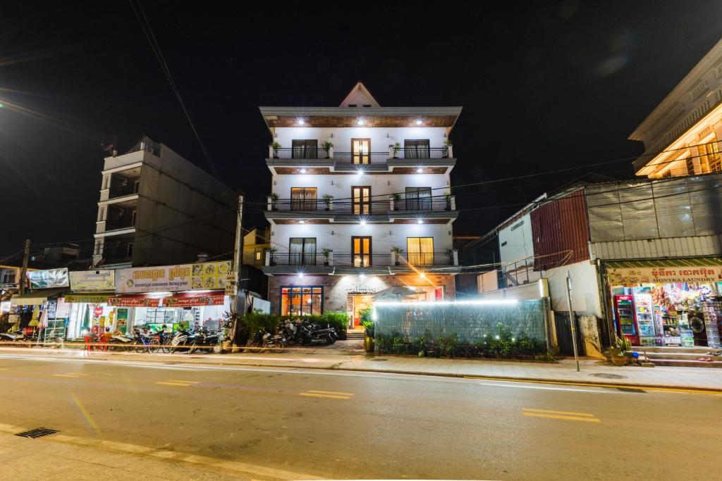 un edificio blanco alto en una calle de la ciudad por la noche en Sihariddh BnB Villa, en Siem Reap