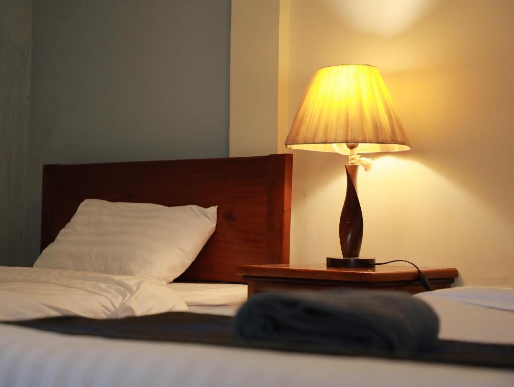 a lamp sitting on a table next to a bed at BLANK GUEST HOUSE in Siem Reap