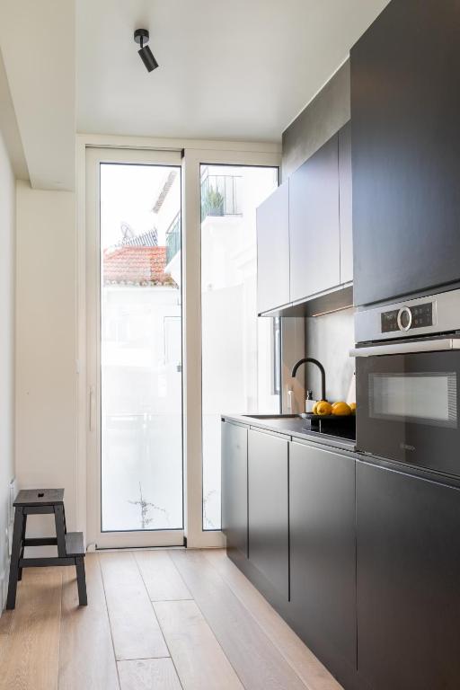 a kitchen with stainless steel appliances and a large window at Villa Sofia Cascais in Cascais