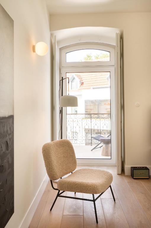 a chair in a room with a window at Villa Sofia Cascais in Cascais