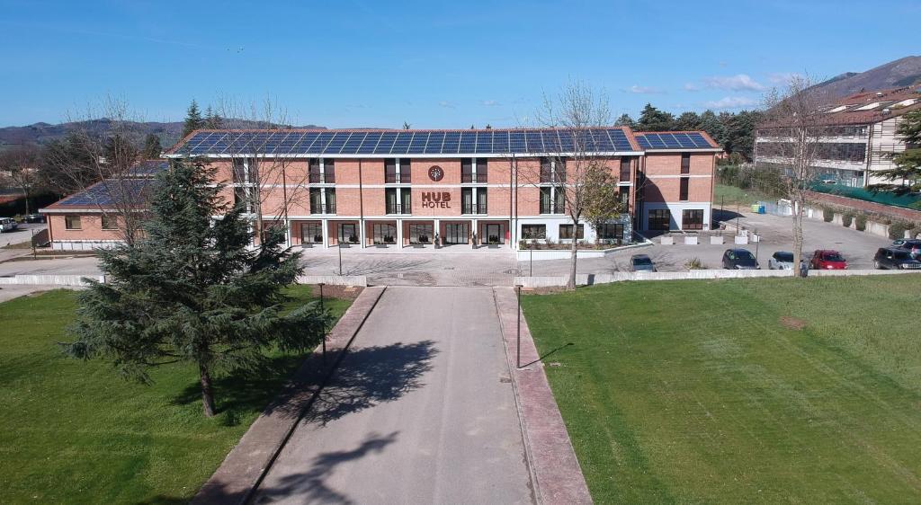 a large brick building with solar panels on it at Hub Hotel in Gubbio
