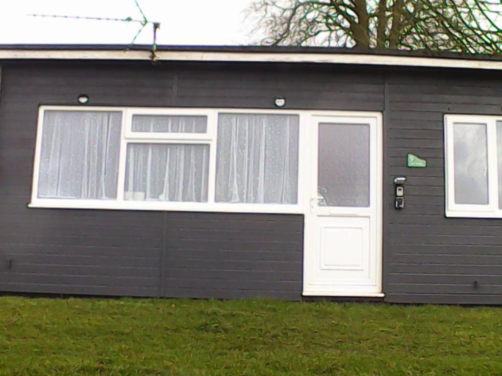 un garaje con una puerta blanca y dos ventanas en 9 Sea Valley en Clovelly