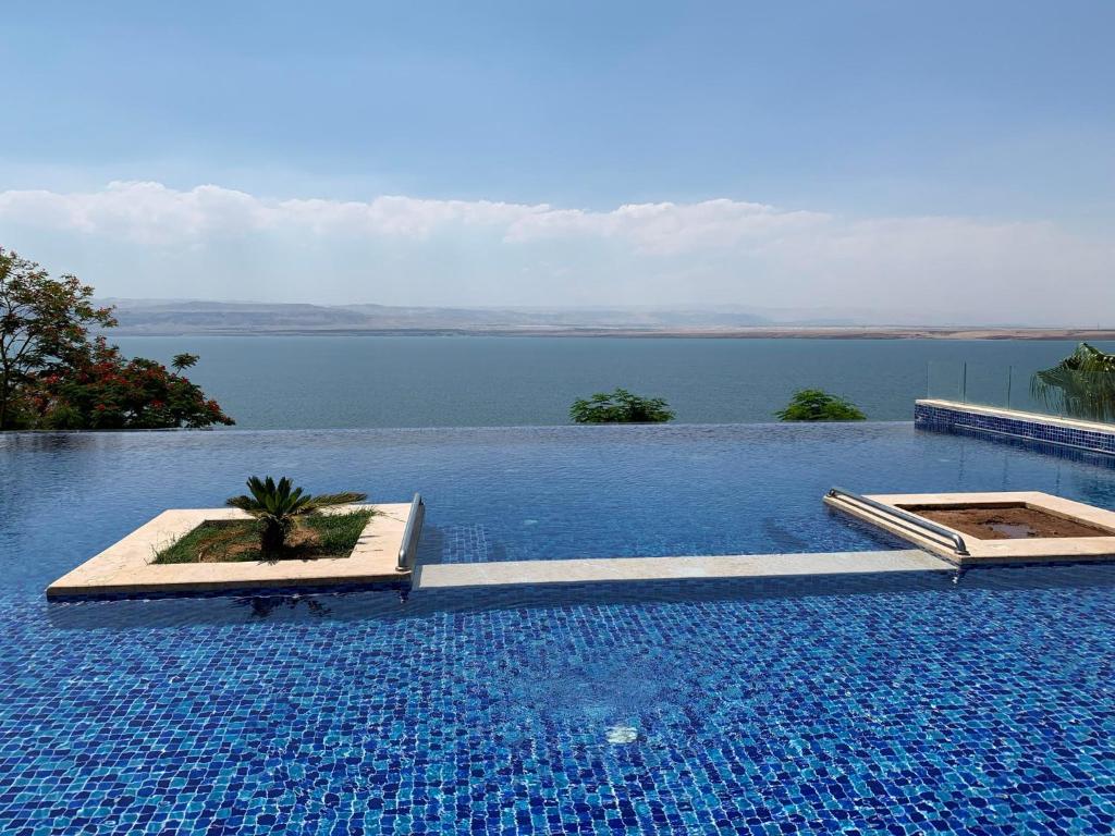 a large swimming pool with a view of the water at Samarah Dead Sea Resort Apartment with Sea View FP4 Traveler Award 2024 Winner in Sowayma