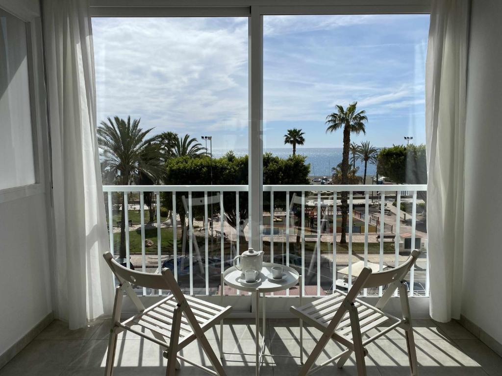 ein Balkon mit Tisch und Stühlen und Blick auf das Meer in der Unterkunft Apartamento 2 habitaciones frontal al mar 3 in Torre del Mar
