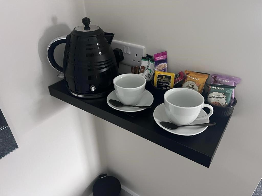 a black shelf with two cups and a tea kettle at Woolaway in Taunton