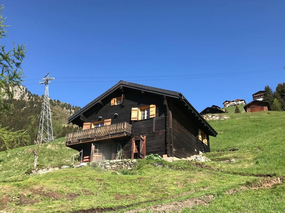 an old wooden house on a hill in a field at Alphütte Riederalp Planier in der Aletsch Arena in Riederalp