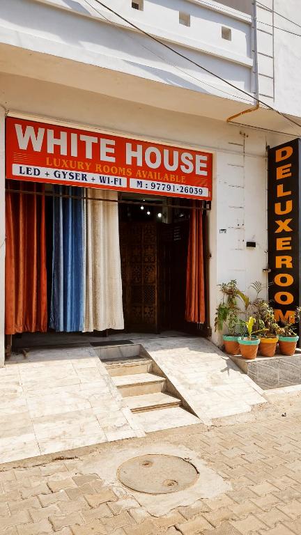 un panneau blanc de la maison à l'avant d'un bâtiment dans l'établissement WHITE HOUSE Luxury Rooms - Loved by Travellers, Couples, Corporates, à Jalandhar