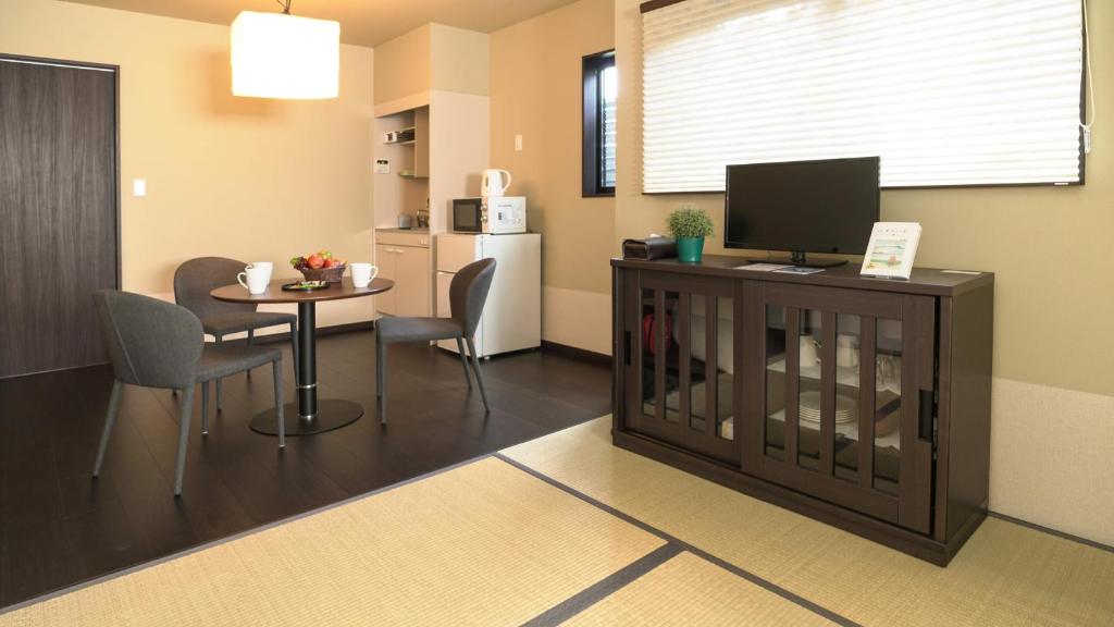 sala de estar con mesa pequeña y cocina en KAMON INN AIHUKA, en Kioto