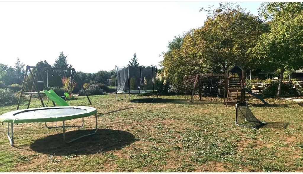 un patio de juegos vacío con dos columpios y un tobogán en n°2 Gîte 4 personnes* au cœur de la nature, en Saint-Aubin-de-Nabirat