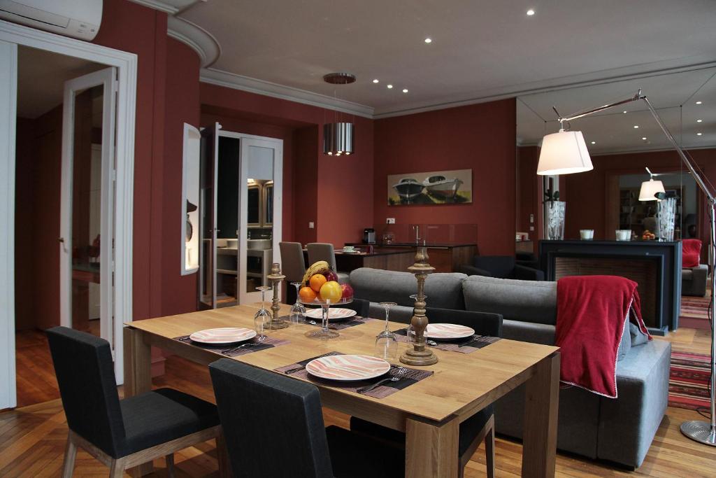 - une salle à manger et un salon avec une table en bois dans l'établissement Maison d'hôtes Bordeaux Centre Le Patio de l'Intendance, à Bordeaux
