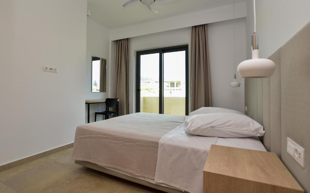 ein Schlafzimmer mit einem großen Bett und einem Fenster in der Unterkunft Rosemary Apartments in Palaiochóra